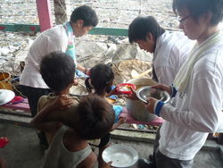 Volunteers serving meals to children in Manila, Philippines